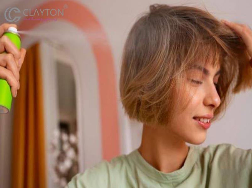  نمای نزدیک از دست‌هایی که شامپو خشک را اسپری می‌کنند