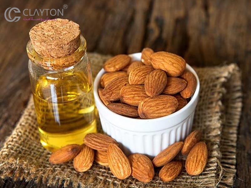 بطری روغن بادام شیرین روی میز چوبی
